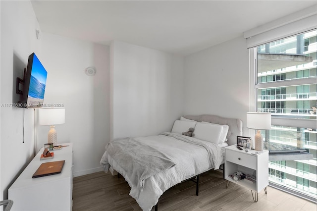 bedroom with multiple windows and wood finished floors