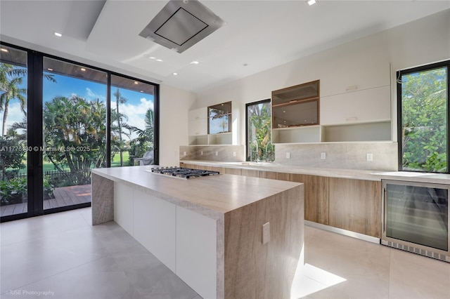 5825 Alton Rd, Miami Beach, FL 33140 - kitchen featuring modern cabinets, floor to ceiling windows, beverage cooler, and backsplash