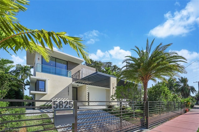 5825 Alton Rd, Miami Beach, FL 33140 - view of front of home featuring a balcony, stucco siding, and fence