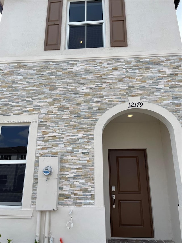 12179 NW 23rd Ct, Miami, FL 33167 - entrance to property featuring stone siding, a high end roof, and stucco siding