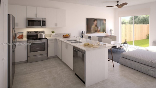 12179 NW 23rd Ct, Miami, FL 33167 - kitchen with appliances with stainless steel finishes, a peninsula, a kitchen breakfast bar, light countertops, and a ceiling fan