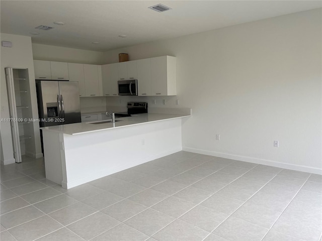 12179 NW 23rd Ct, Miami, FL 33167 - kitchen with stainless steel appliances, light tile patterned floors, light countertops, and a peninsula
