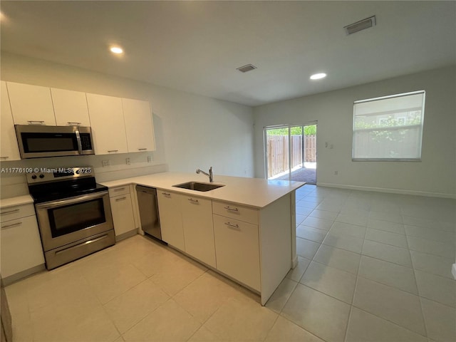 12179 NW 23rd Ct, Miami, FL 33167 - kitchen featuring stainless steel appliances, light countertops, a peninsula, light tile patterned flooring, and recessed lighting
