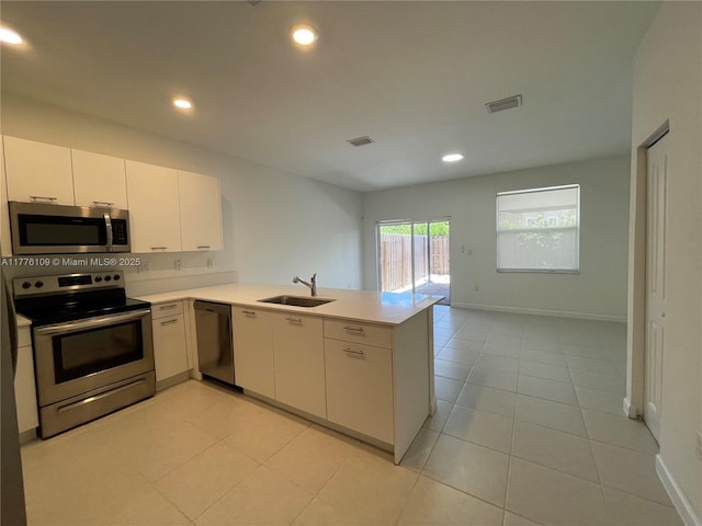 12179 NW 23rd Ct, Miami, FL 33167 - kitchen featuring stainless steel appliances, a peninsula, light countertops, recessed lighting, and light tile patterned floors