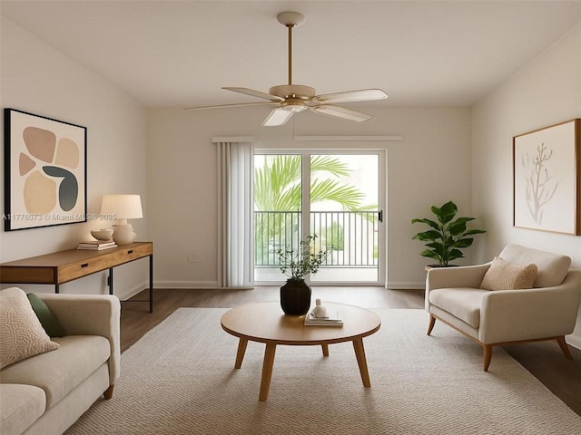 living area with baseboards, ceiling fan, and wood finished floors