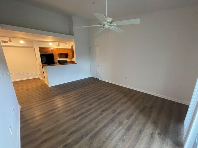 unfurnished living room with a ceiling fan, high vaulted ceiling, dark wood-type flooring, and baseboards
