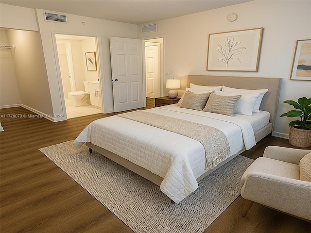 bedroom with wood finished floors, baseboards, ensuite bath, and visible vents