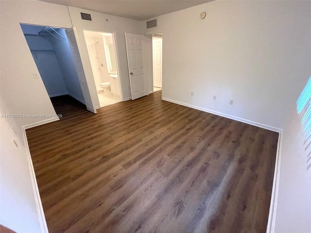 interior space featuring baseboards, visible vents, and dark wood-style flooring