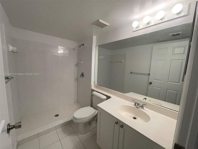 bathroom featuring visible vents, toilet, tile patterned flooring, and tiled shower