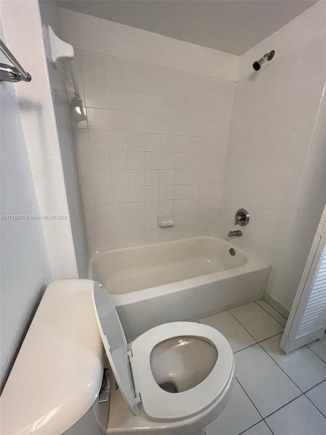 bathroom with bathtub / shower combination, toilet, and tile patterned flooring