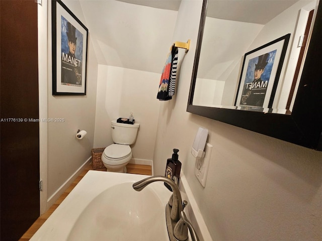 400 Valencia Ave Unit 2, Coral Gables, FL 33134 - bathroom featuring toilet, wood finished floors, vaulted ceiling, baseboards, and a sink