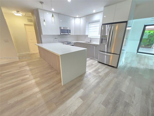kitchen featuring modern cabinets, white cabinets, a peninsula, and appliances with stainless steel finishes