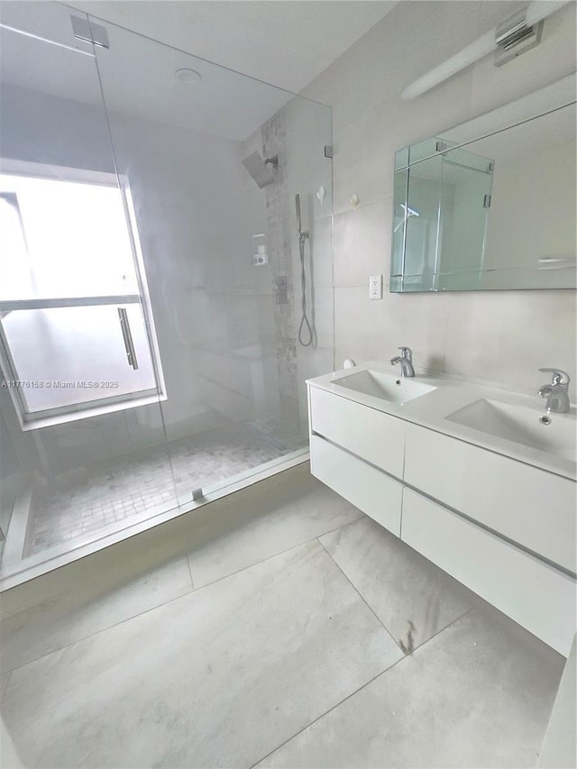 bathroom featuring double vanity, a sink, and walk in shower
