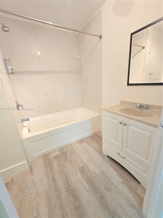 full bath with shower / bathing tub combination, vanity, and wood finished floors