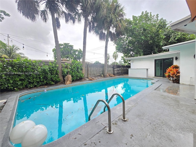 view of swimming pool with a patio area, fence, and a fenced in pool