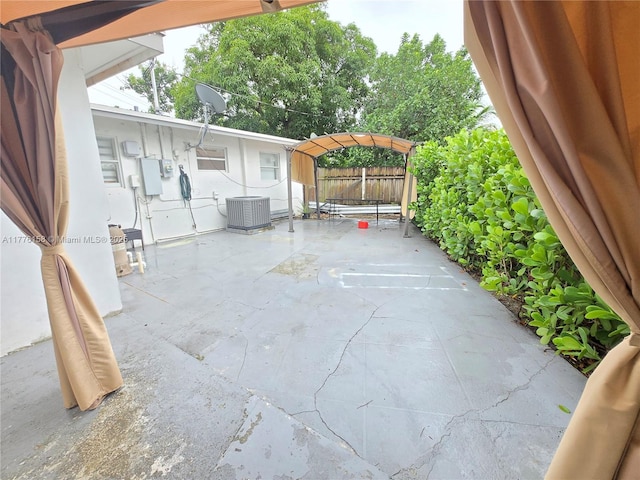 view of patio with central AC and fence