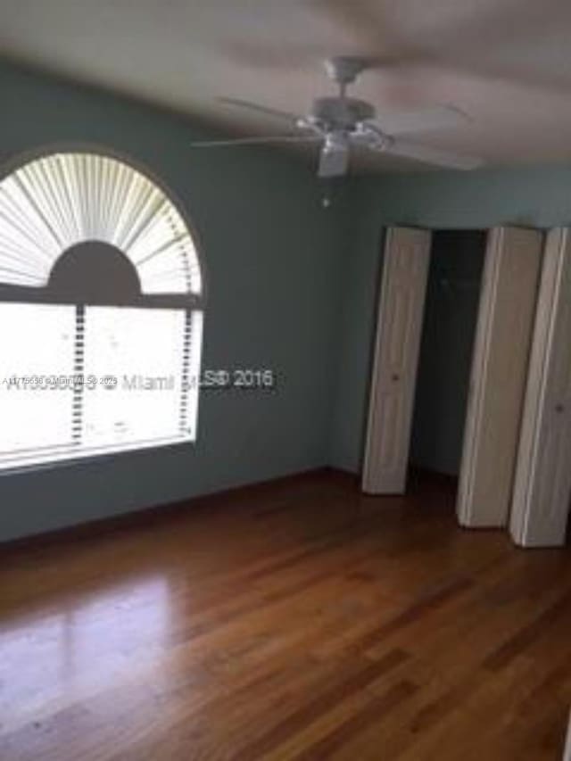 10420 SW 160th Ct, Miami, FL 33196 - unfurnished bedroom with a ceiling fan, wood finished floors, and multiple windows