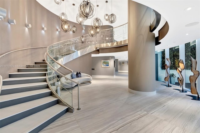 staircase with a towering ceiling and recessed lighting