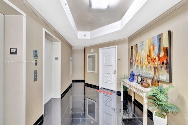 hall featuring crown molding, baseboards, a raised ceiling, elevator, and tile patterned flooring