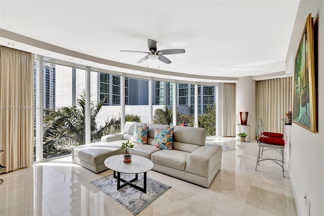 living room featuring marble finish floor, a wall of windows, and a ceiling fan