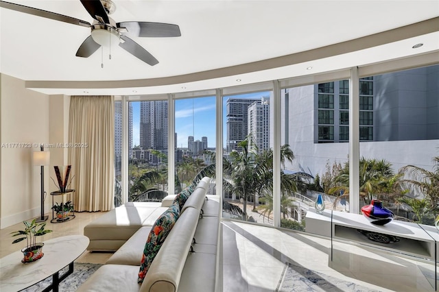 tiled living room with a ceiling fan, a city view, and a wall of windows