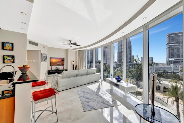 living area featuring expansive windows, ceiling fan, visible vents, and recessed lighting