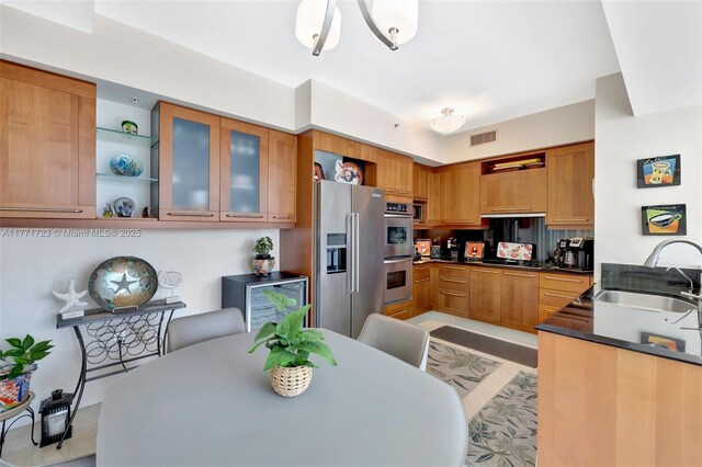 333 Las Olas Way Unit 1007, Fort Lauderdale, FL 33301 - kitchen with a sink, stainless steel appliances, dark countertops, glass insert cabinets, and extractor fan