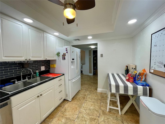 437 Golden Isles Dr Unit 9B-C, Hallandale Beach, FL 33009 - kitchen with dark countertops, a sink, crown molding, decorative backsplash, and white refrigerator with ice dispenser
