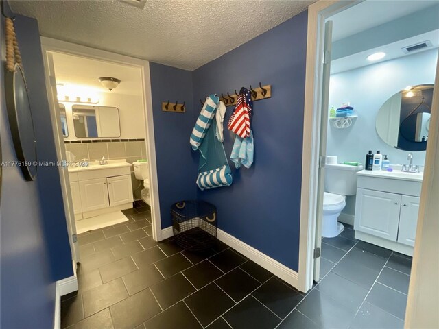 437 Golden Isles Dr Unit 9B-C, Hallandale Beach, FL 33009 - bathroom with toilet, a textured ceiling, tile patterned flooring, and vanity