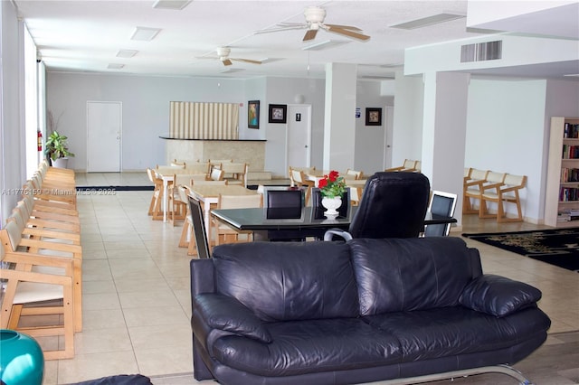 living room featuring visible vents, light tile patterned flooring, and ceiling fan