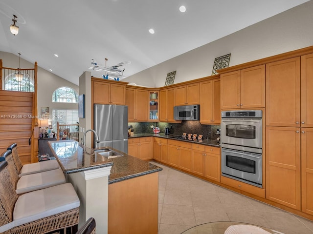 17794 SW 47th St, Miramar, FL 33029 - kitchen featuring appliances with stainless steel finishes, a sink, backsplash, dark stone counters, and glass insert cabinets