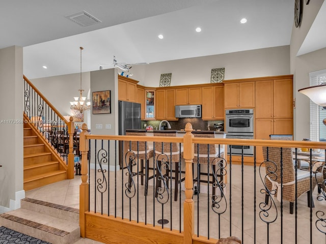 17794 SW 47th St, Miramar, FL 33029 - kitchen featuring stainless steel appliances, light tile patterned flooring, a chandelier, tasteful backsplash, and glass insert cabinets