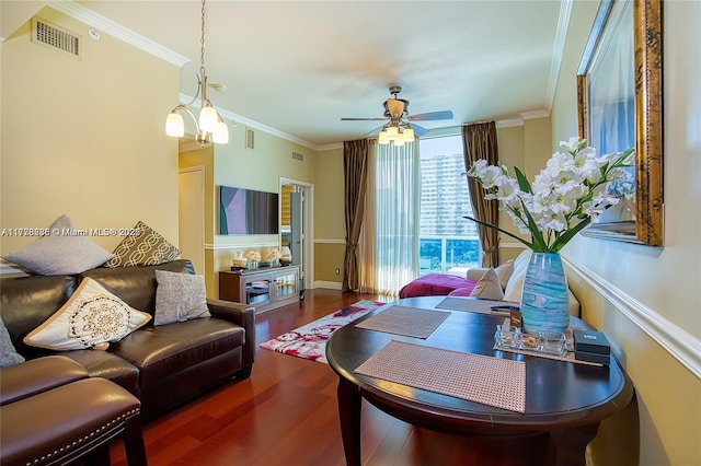 living area with crown molding, wood finished floors, visible vents, and a ceiling fan