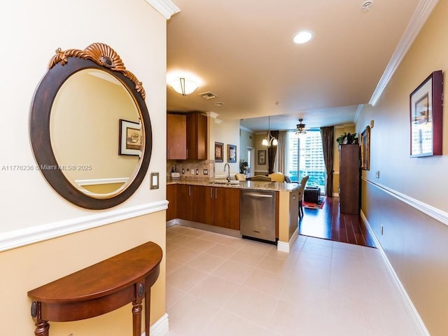 kitchen with visible vents, stainless steel dishwasher, ornamental molding, a peninsula, and brown cabinetry