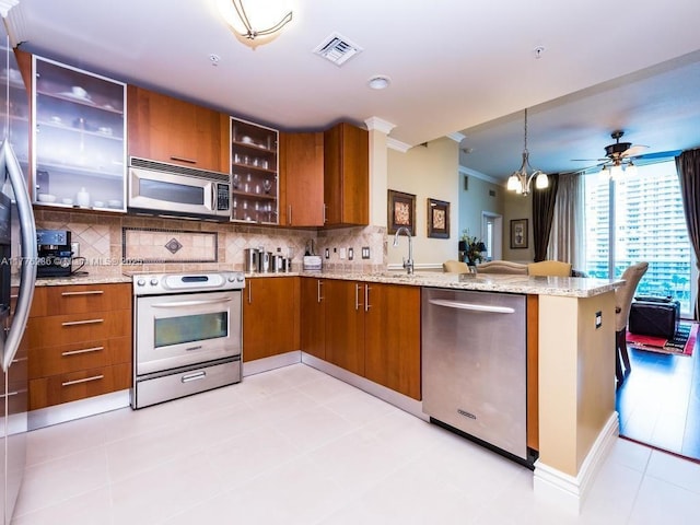 kitchen featuring brown cabinets, crown molding, visible vents, and appliances with stainless steel finishes
