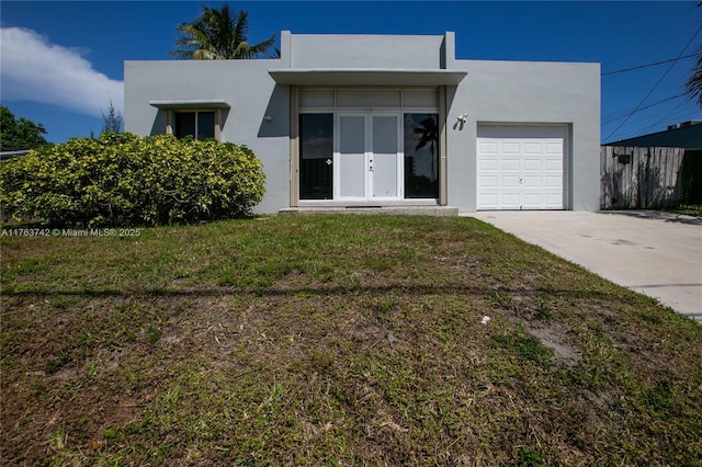 4750 SW 43rd Ave, Dania Beach, FL 33314 - view of front of house with driveway, stucco siding, an attached garage, and a front lawn