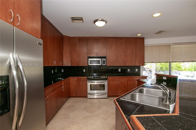 4750 SW 43rd Ave, Dania Beach, FL 33314 - kitchen with stainless steel appliances, a sink, dark countertops, visible vents, and backsplash
