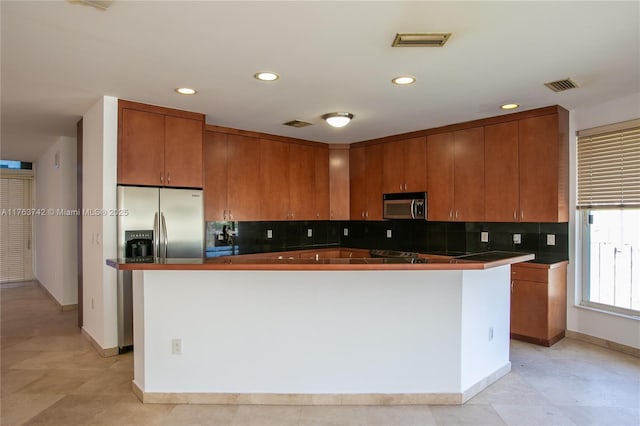 4750 SW 43rd Ave, Dania Beach, FL 33314 - kitchen with backsplash, brown cabinets, appliances with stainless steel finishes, and visible vents