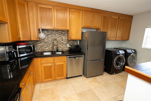 2700 Casita Way Unit 2150, Delray Beach, FL 33445 - kitchen featuring stainless steel appliances, washer and dryer, a sink, tasteful backsplash, and brown cabinets