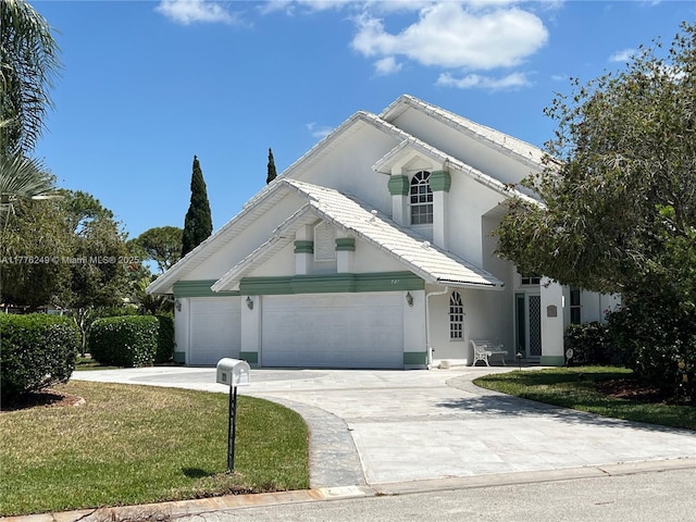 721 Spring Lake Dr, Melbourne, FL 32940 - traditional home featuring a front yard, an attached garage, a tile roof, concrete driveway, and stucco siding