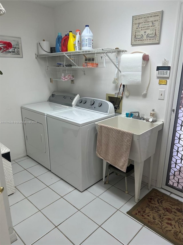721 Spring Lake Dr, Melbourne, FL 32940 - clothes washing area featuring light tile patterned floors, washer and clothes dryer, and laundry area