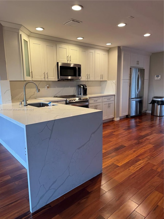 2912 NW 80th Ave, Sunrise, FL 33322 - kitchen with a sink, stainless steel appliances, dark wood finished floors, a peninsula, and light stone countertops