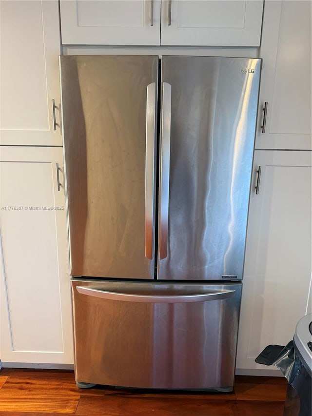 2912 NW 80th Ave, Sunrise, FL 33322 - room details with freestanding refrigerator, wood finished floors, and white cabinetry