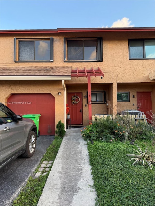 2912 NW 80th Ave, Sunrise, FL 33322 - townhome / multi-family property featuring stucco siding, aphalt driveway, and a garage