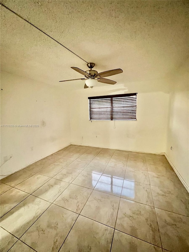 unfurnished room featuring a ceiling fan and a textured ceiling