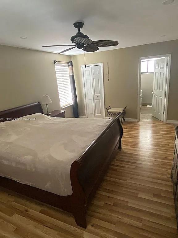 bedroom with a closet, ceiling fan, baseboards, and wood finished floors