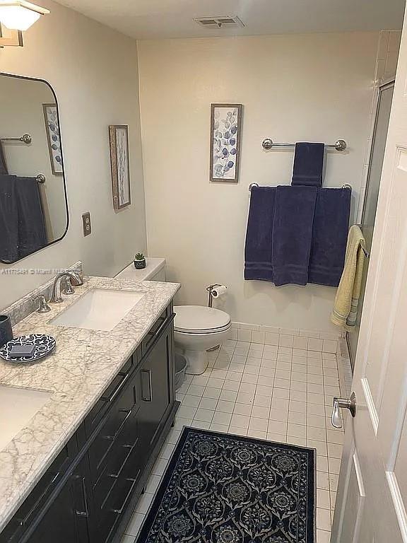 6342 W Longboat Ln W Unit C201, Boca Raton, FL 33433 - bathroom with toilet, double vanity, and tile patterned floors
