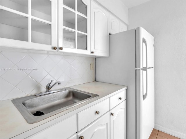 1408 Brickell Bay Dr Unit 816, Miami, FL 33131 - kitchen featuring tasteful backsplash, glass insert cabinets, white cabinets, a sink, and light countertops
