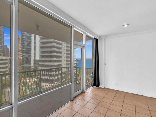 1408 Brickell Bay Dr Unit 816, Miami, FL 33131 - tiled empty room with a city view, crown molding, expansive windows, and a water view
