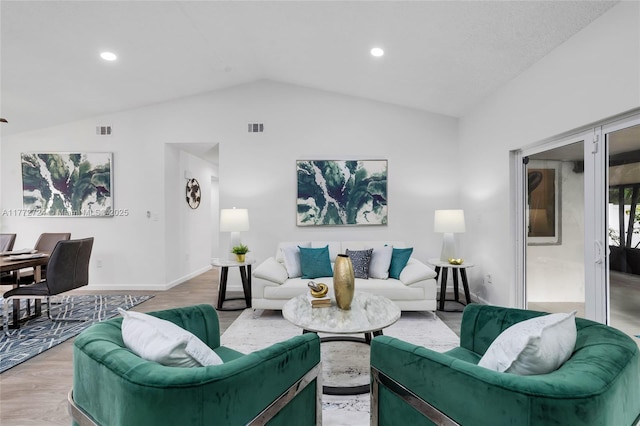 living room with vaulted ceiling, visible vents, and light wood-style floors